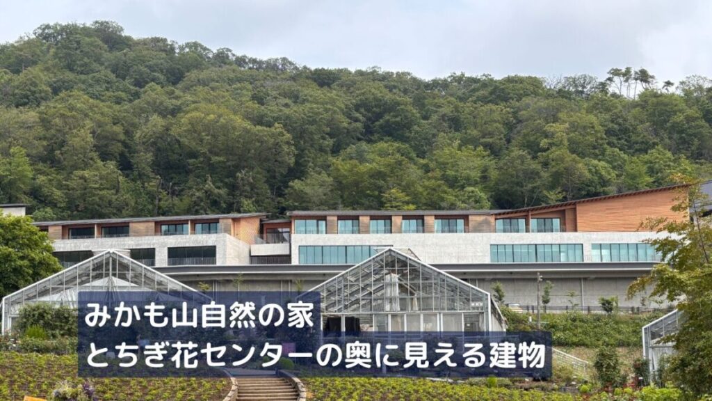 とちぎ花センターの奥に見えるみかも山自然の家の外観画像