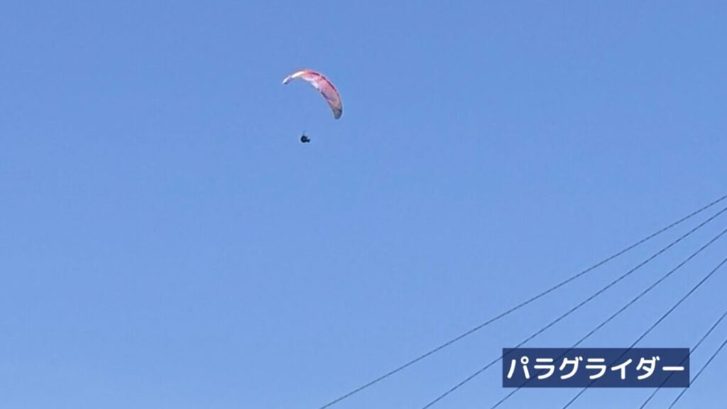 青空にパラグライダーが飛んでいる様子の画像