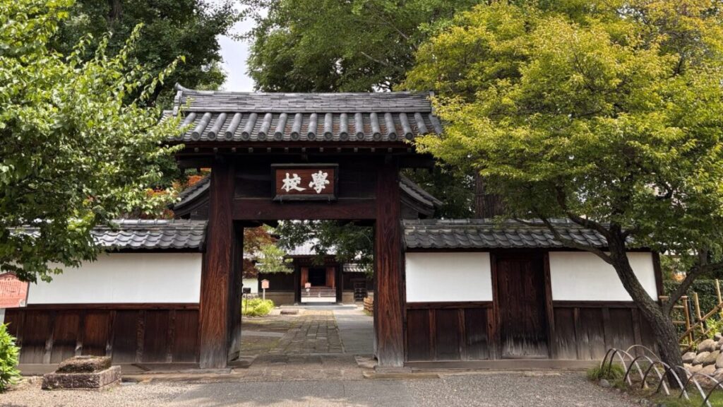 学校門の額と茅葺屋根
